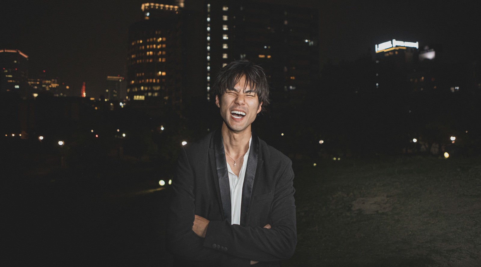 「深夜の公園で大笑いする男性」の写真［モデル：村田裕章］