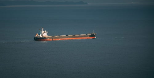海上にいる長い貨物船の写真