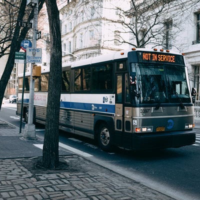バス停留所から発進するバス（ニューヨークの市街）の写真