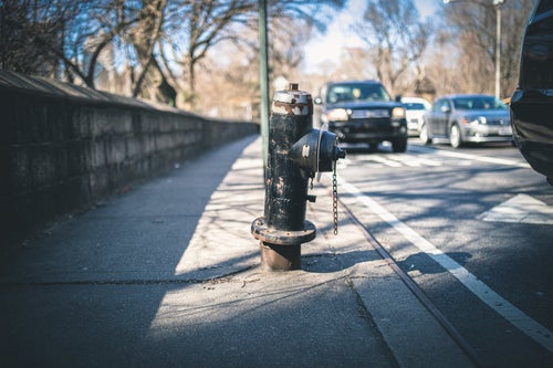 歩道に設置された錆び付く消火栓の写真