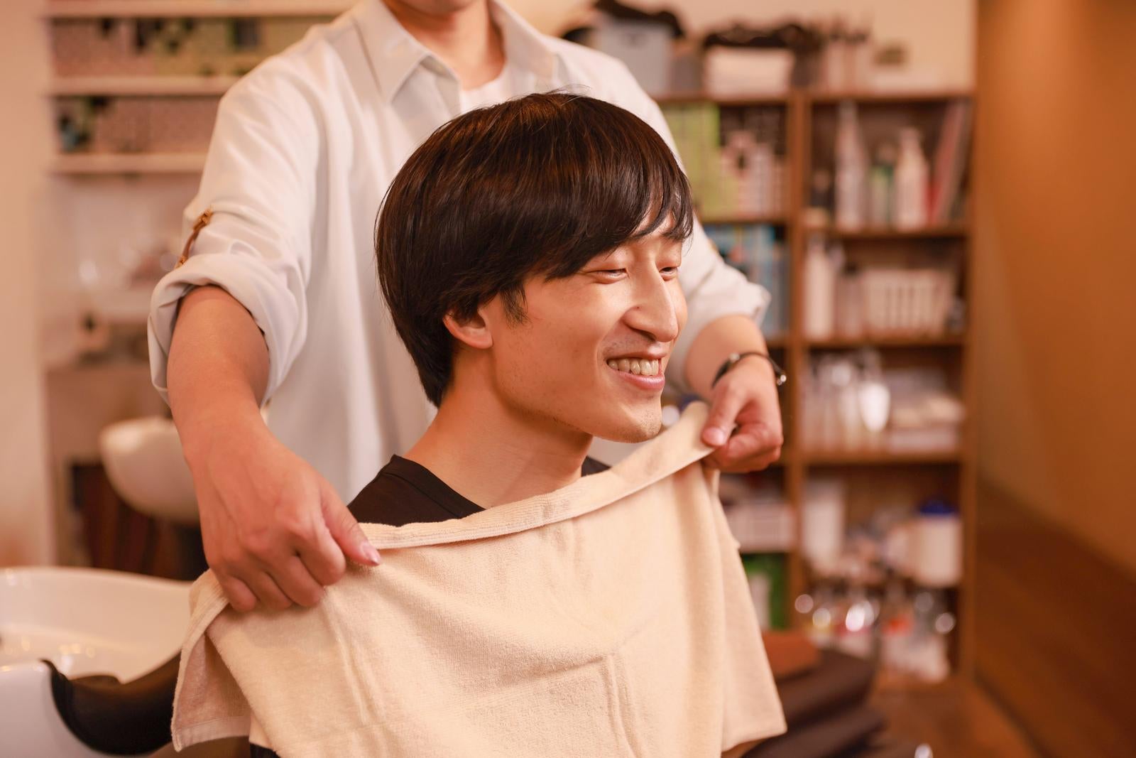 「落ち着いた雰囲気の店内でリラックスした表情の男性」の写真［モデル：あづま］