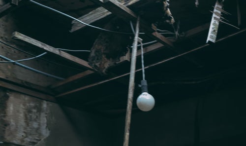 崩れゆく天井と電球の写真