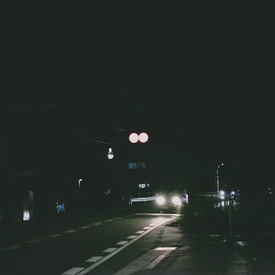 夜間走行する車のヘッドライトの写真