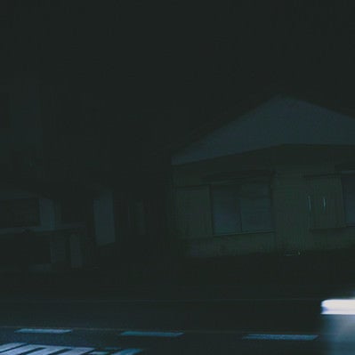 深夜帯の民家前を走り去る車の残像の写真