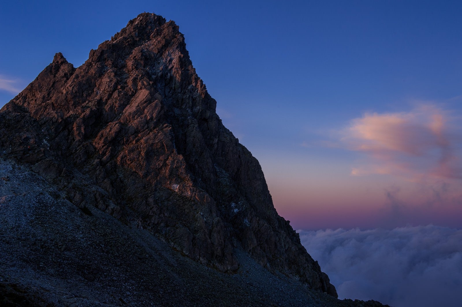 「日没後の残光に淡く照らされた槍ヶ岳」の写真