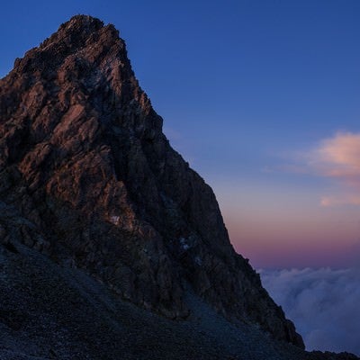 日没後の残光に淡く照らされた槍ヶ岳の写真