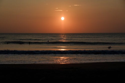 朝日を背に海岸に打ち寄せる波（千葉県一宮町）の写真