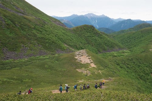 北アルプスの中央にある乗鞍新登山道と登山者の列の写真