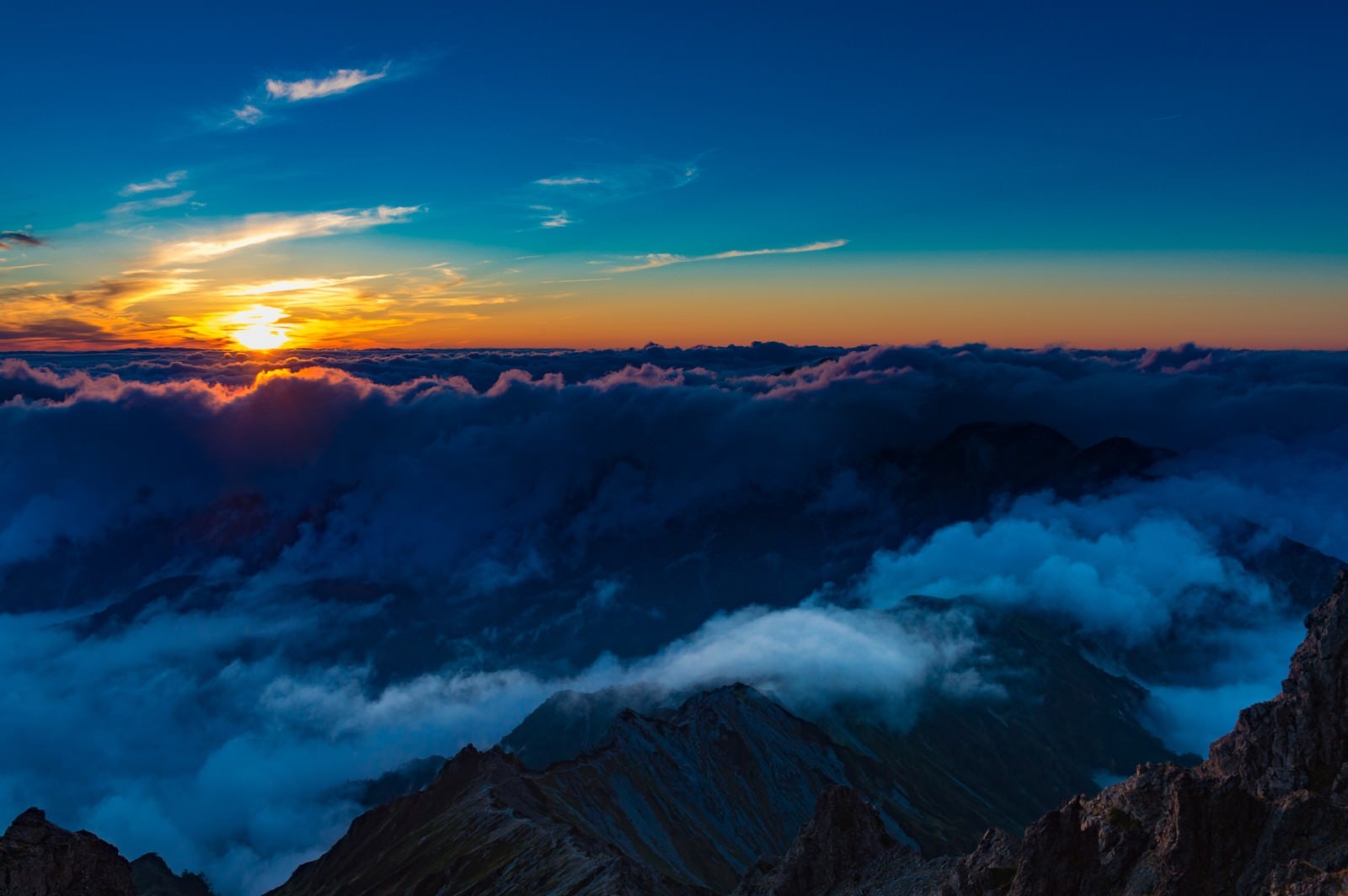 「槍ヶ岳山頂から見下ろす夕暮れの北アルプスの山々」の写真