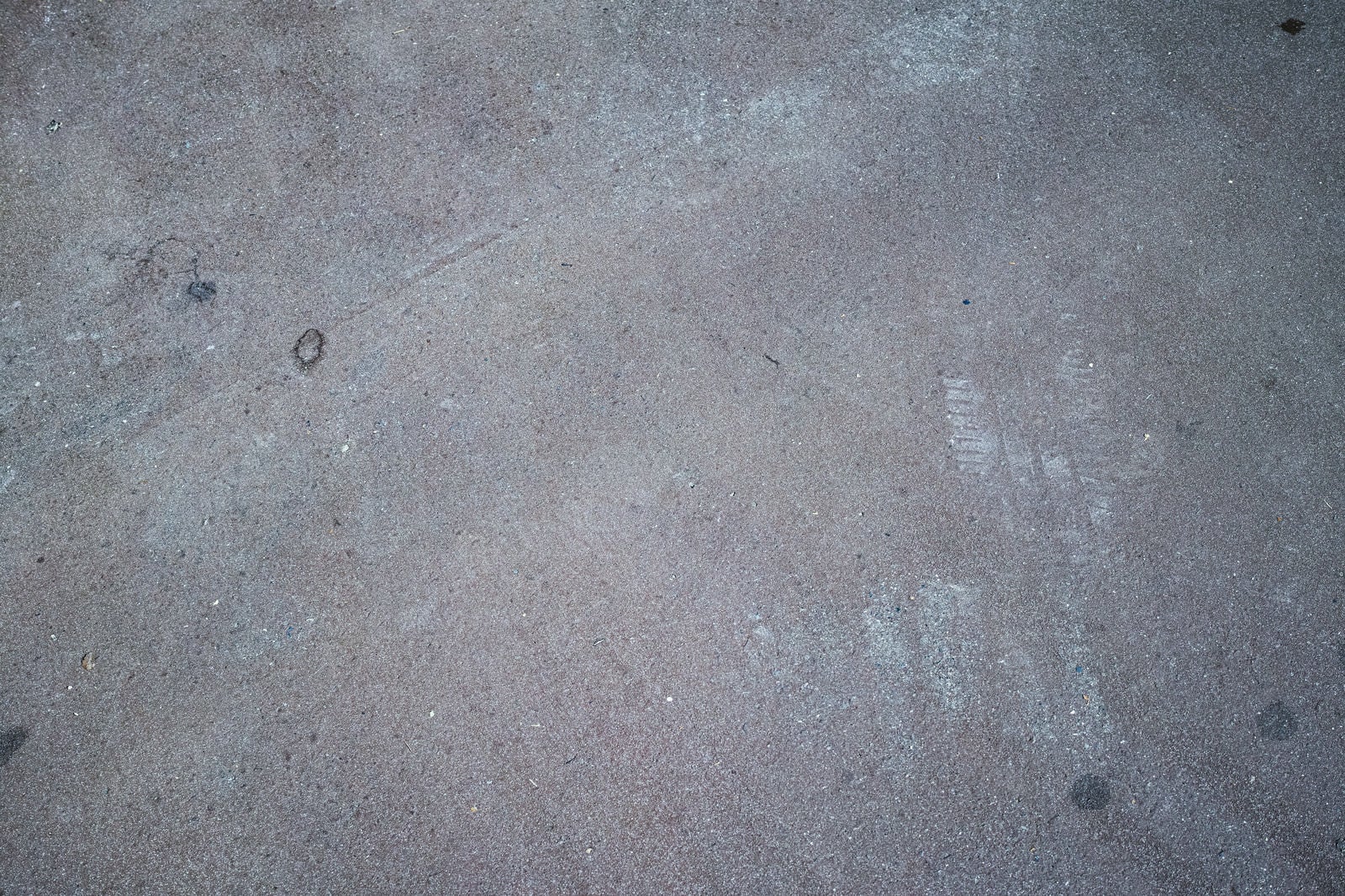 「うっすらとアスファルトに残るタイヤ跡（テクスチャー）」の写真
