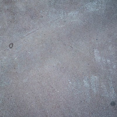 うっすらとアスファルトに残るタイヤ跡（テクスチャー）の写真