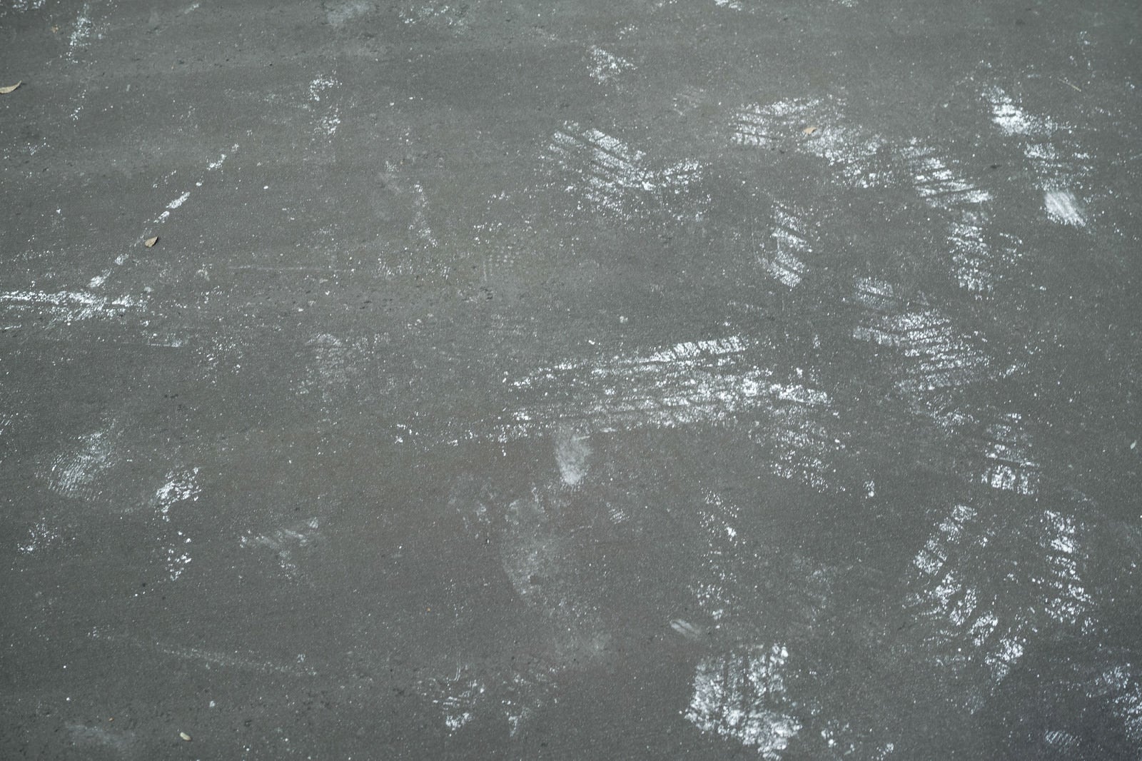 「コンクリートに付いた足跡とタイヤ跡（テクスチャー）」の写真
