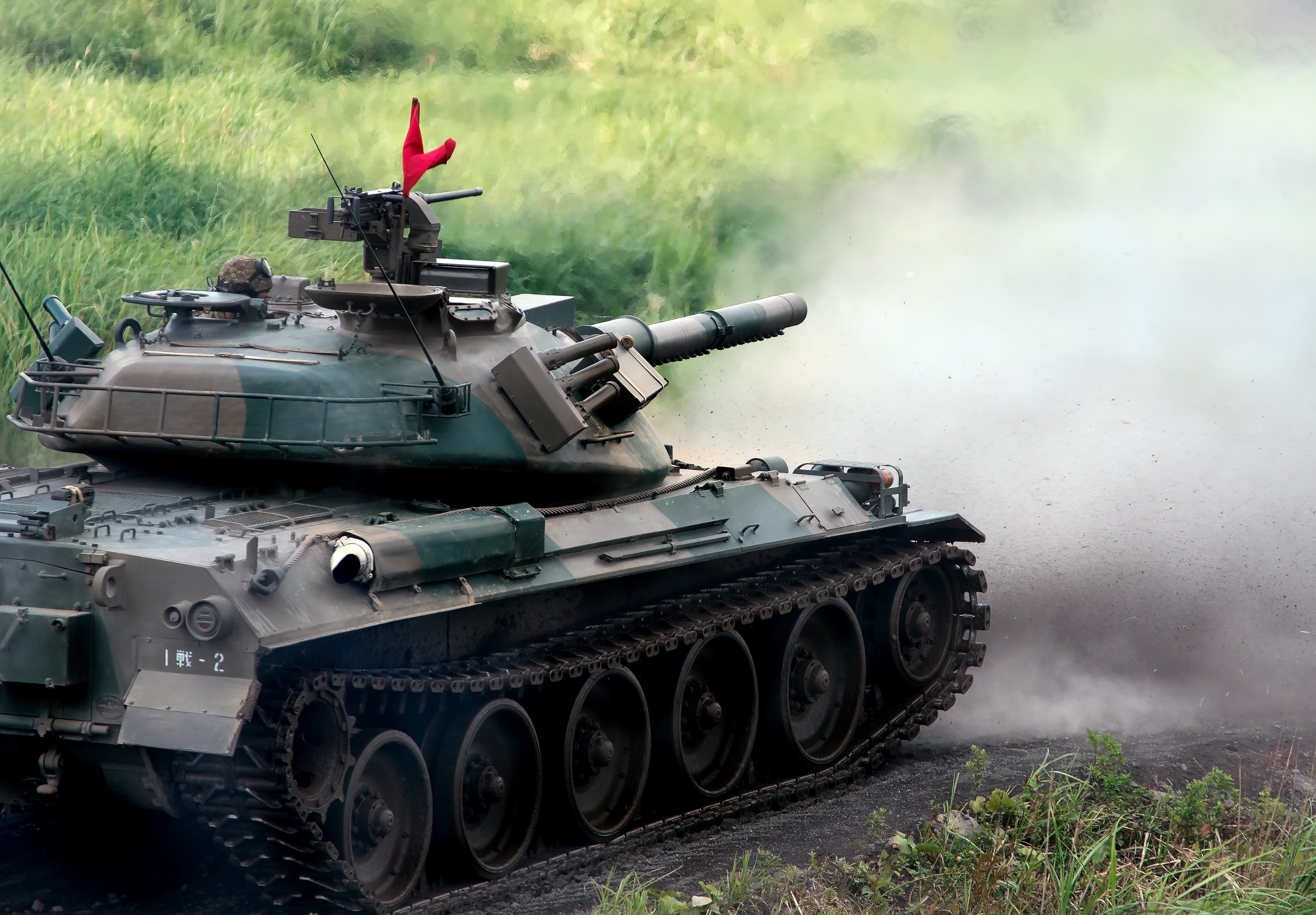 74式戦車と、発射直後に巻き上げられる土煙の無料の写真素材