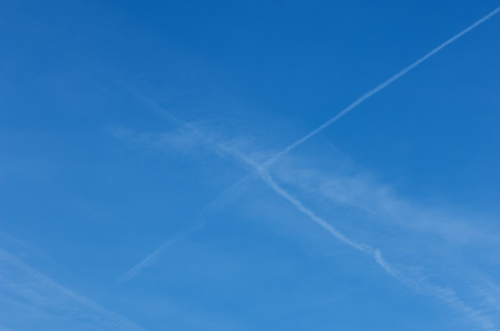 「飛行機雲が交差して消えていく」の写真