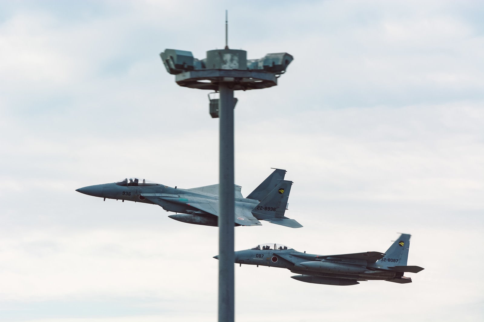 「鉄塔被りの併走する戦闘機（F-15）」の写真
