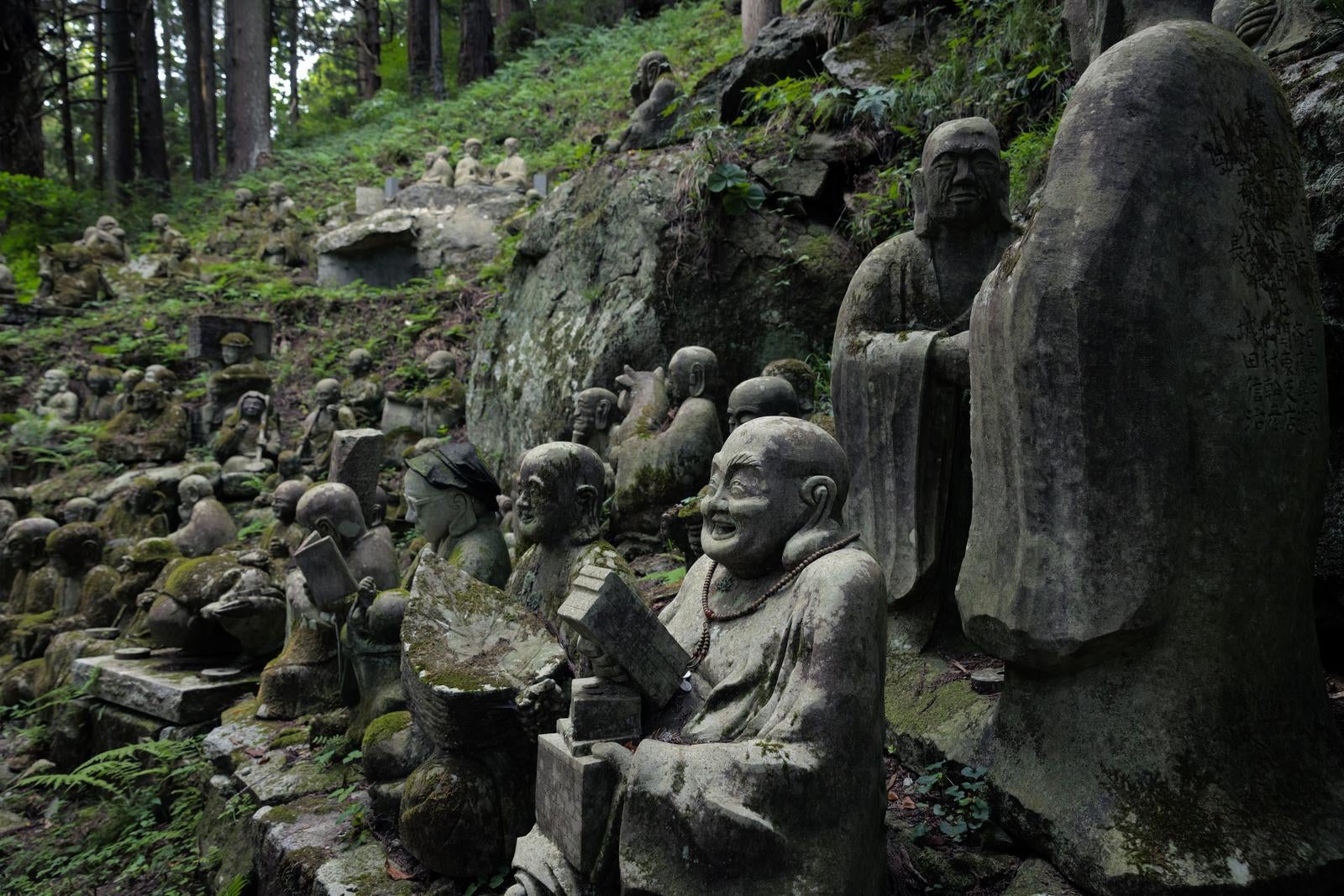 「東堂山満福寺の境内に結集する羅漢の石像」の写真