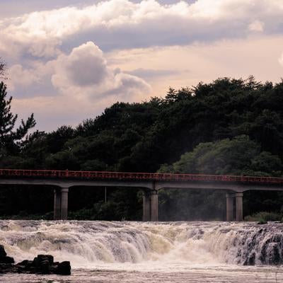 乙字ヶ滝の水飛沫を通して見る乙字橋の風情の写真