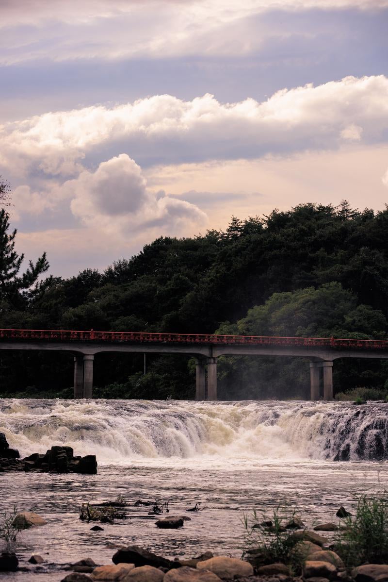 「乙字ヶ滝の水飛沫を通して見る乙字橋の風情」の写真