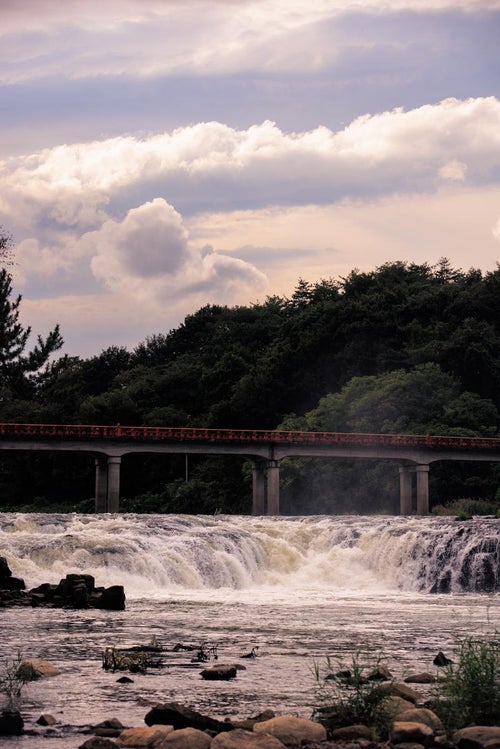 乙字ヶ滝の水飛沫を通して見る乙字橋の風情の写真