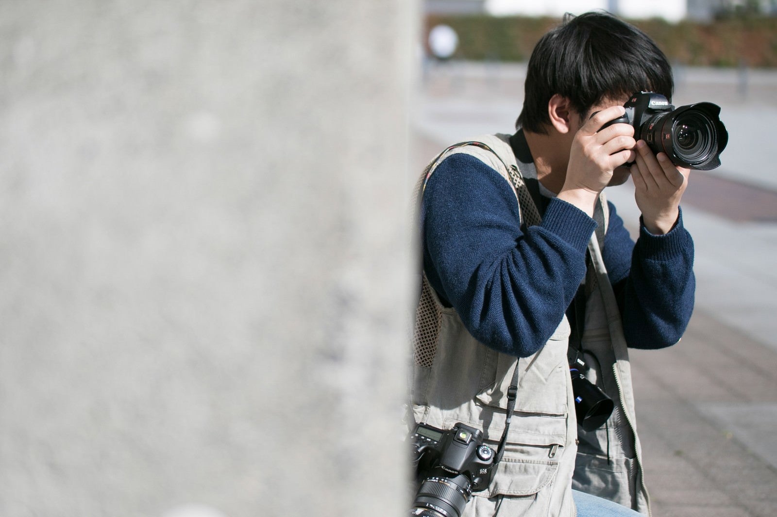 「ベストなポジションを探すカメラマン」の写真［モデル：大川竜弥］