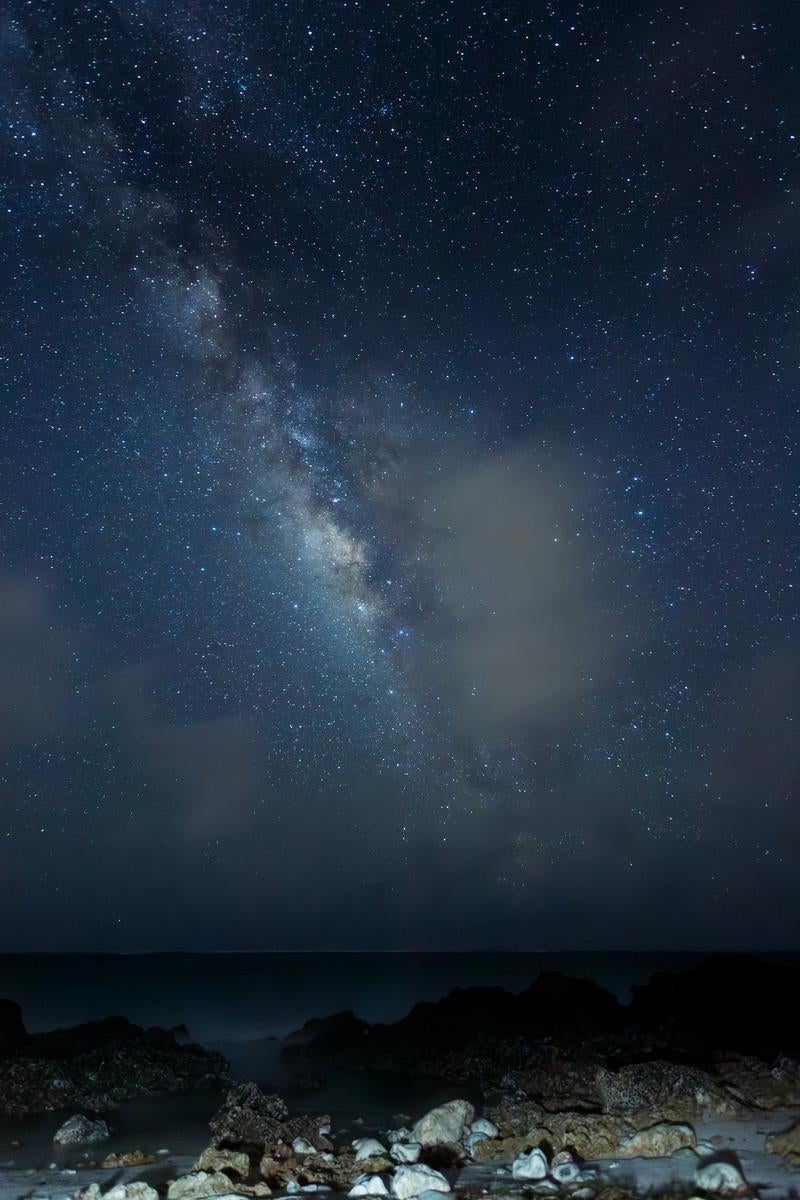 「夜空に広がる天の川と静寂な海辺」の写真