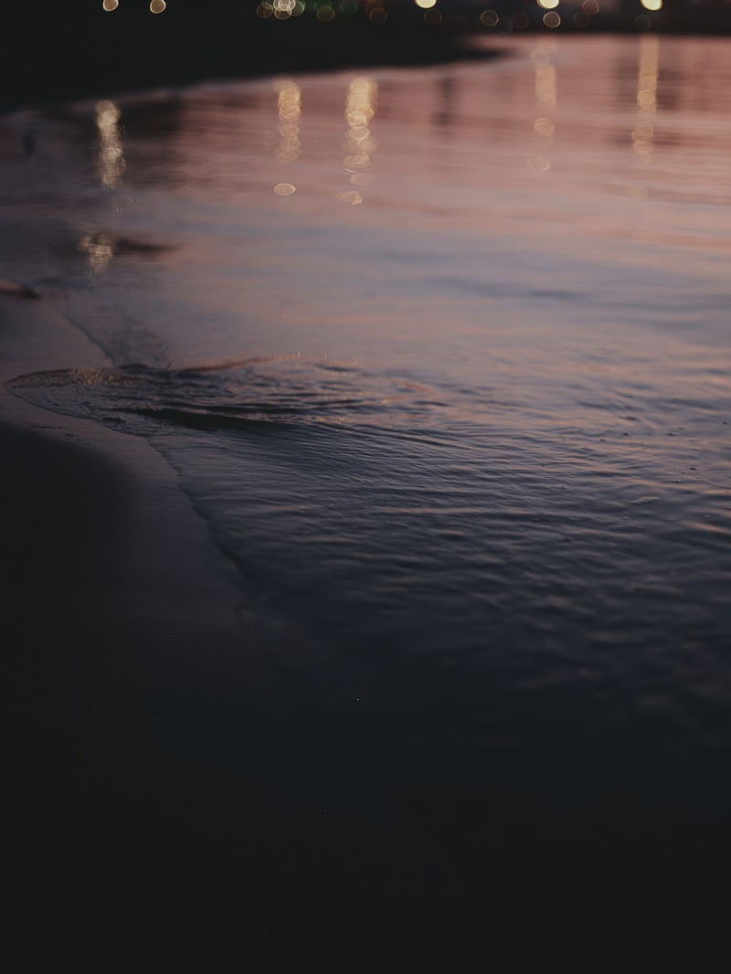 「夕日を反射する波打ち際」の写真