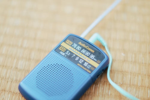 畳の上に置かれた携帯ラジオの写真