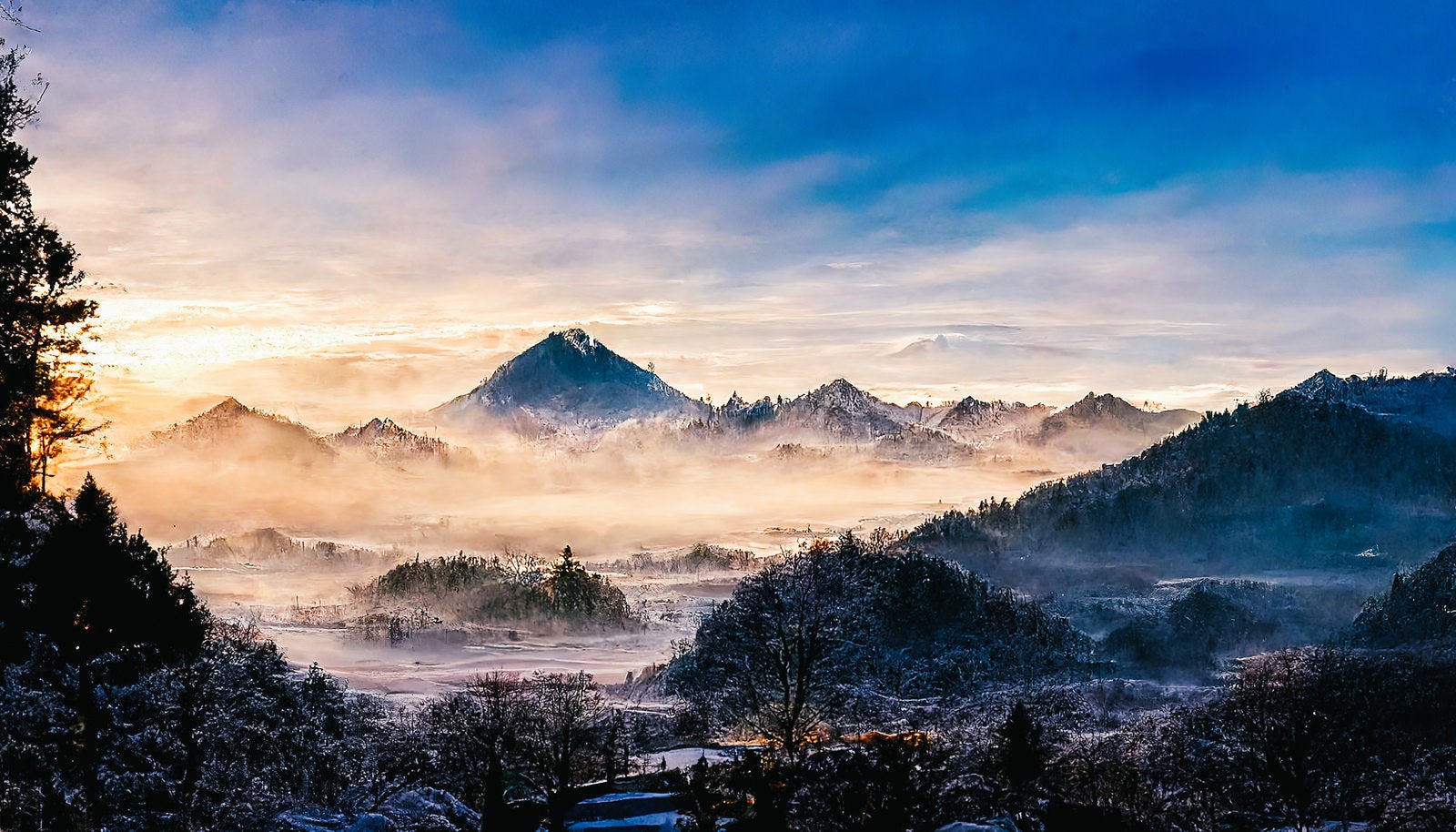 「朝霧が漂う雪山」の写真