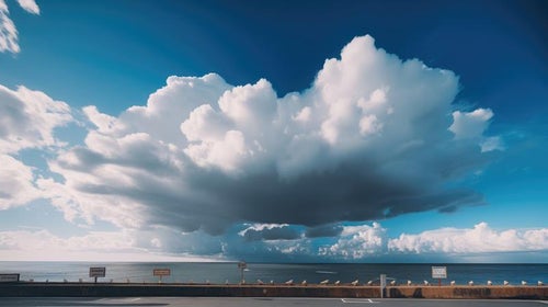 遠くの海の上で雨が降っている大きな雨雲の写真