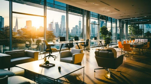 ガラス張りの空間と夕焼けのオフィスの写真