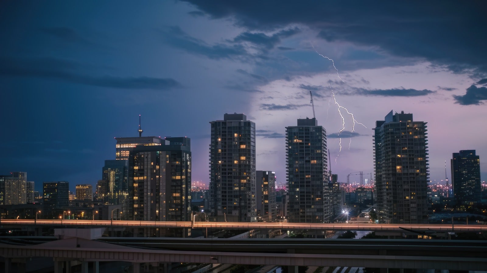 「高層ビルが立ち並ぶ都会に雷雲」の写真