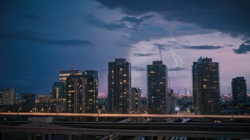 高層ビルが立ち並ぶ都会に雷雲の写真