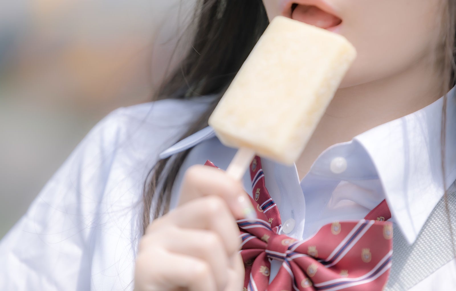「アイスを食べる女子高生の口元」の写真［モデル：石投げて美奈代］