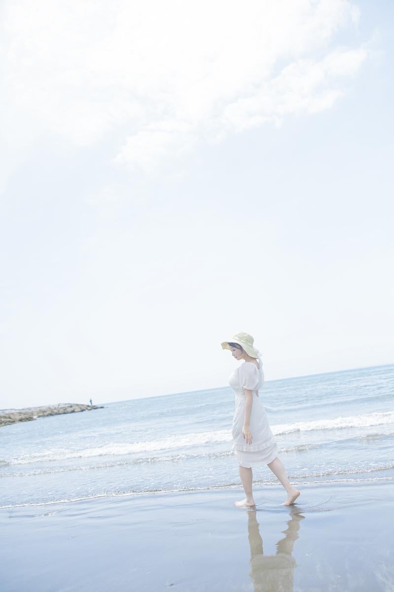 岩井海水浴場の波打ち際を歩く女性の写真
