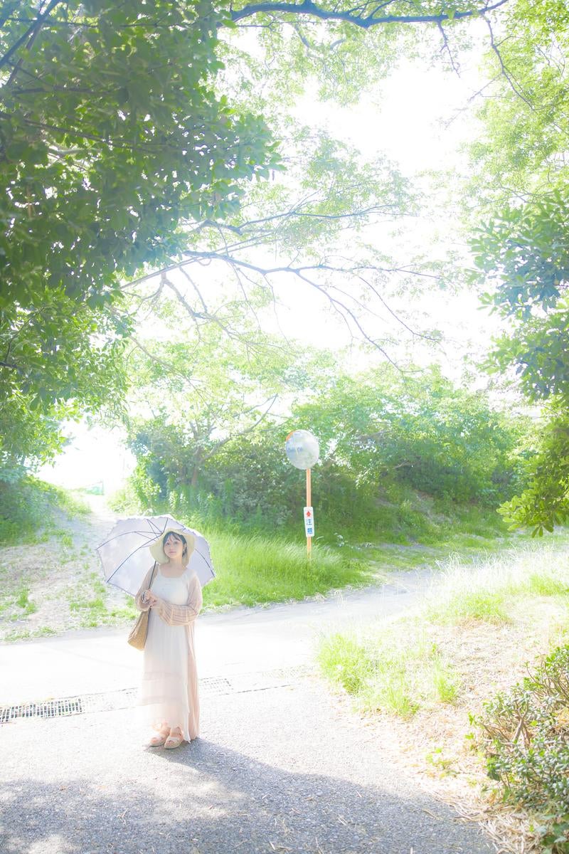 「緑に囲まれた夏の日差しと日傘をさす女性」の写真［モデル：茜さや］