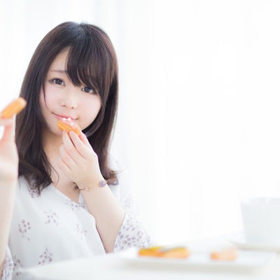 ひとつだけならあげてもいいよ、エクレアを手に持つ女性の写真