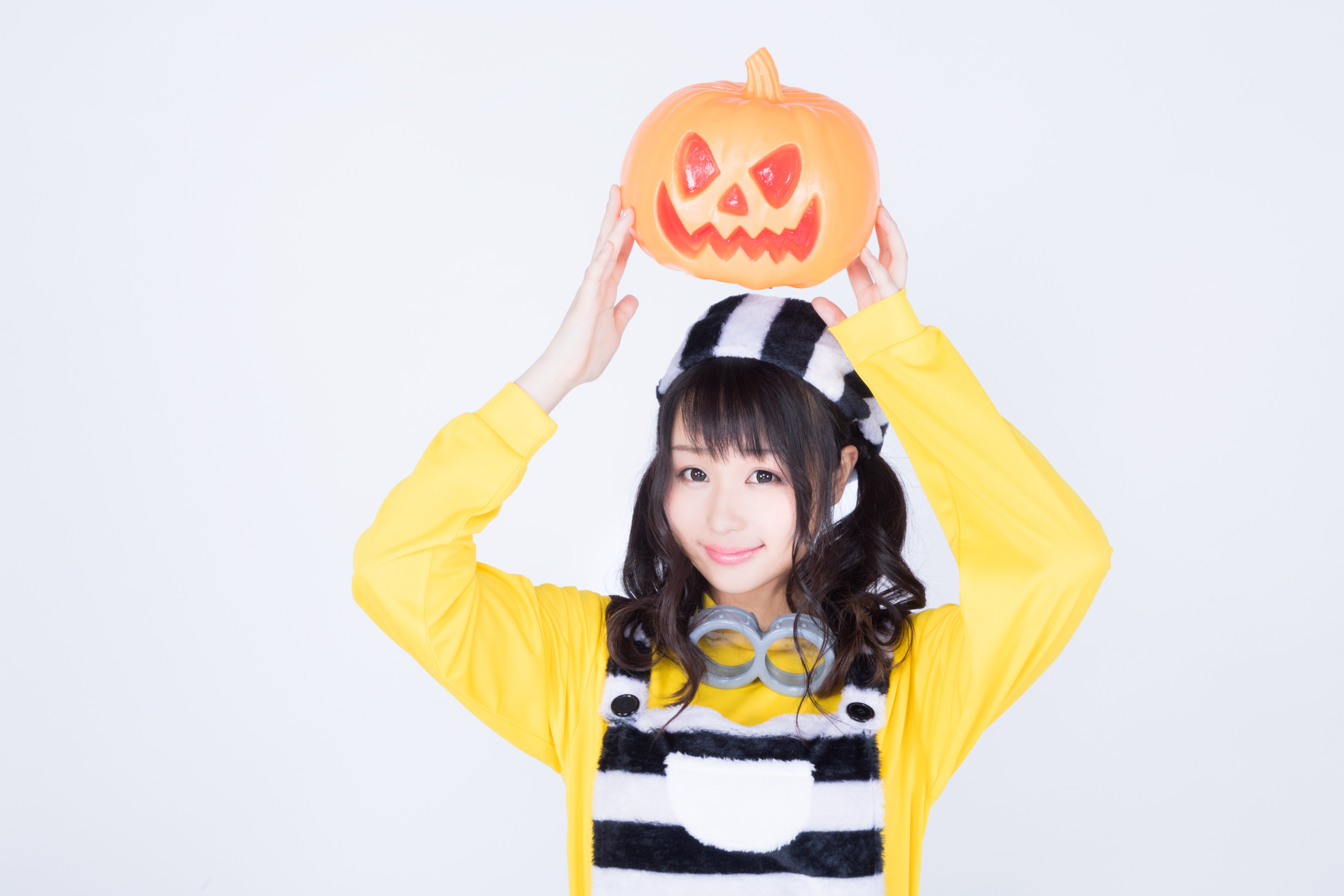 ハロウィンのかぼちゃお化けを持ち上げる仮装女子の無料の写真素材