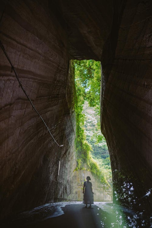 高さ10mもある燈籠坂大師の切通しトンネルを見上げる女性の写真