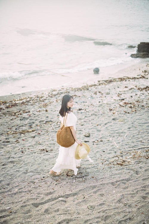 沖ノ島の海岸を歩く女性の写真