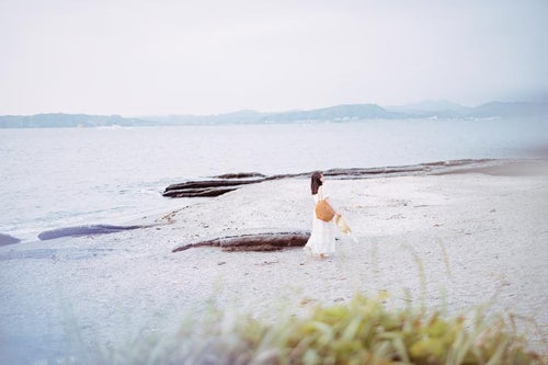 沖ノ島（千葉県）のシェルビーチを散策する女性の写真