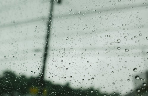 雨空と窓についた水滴の写真
