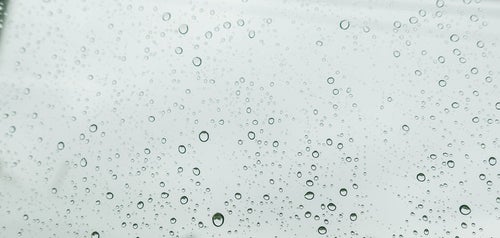 窓ガラスと雨の水滴の写真