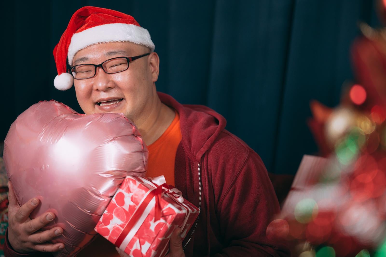 「クリスマスプレゼンに笑顔が溢れる男性」の写真［モデル：あまやん］