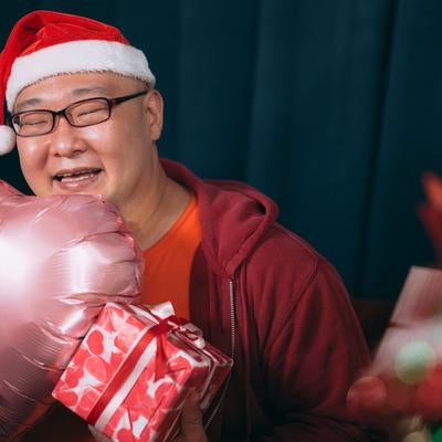 クリスマスプレゼンに笑顔が溢れる男性の写真
