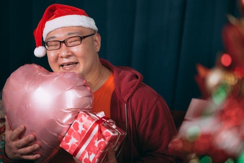 クリスマスプレゼンに笑顔が溢れる男性の写真