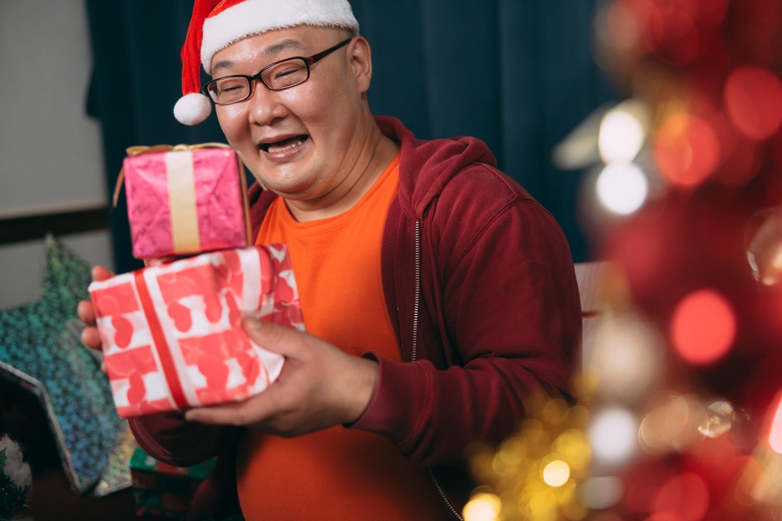 「サプライズでクリスマスプレゼントを受け取る男性」の写真［モデル：あまやん］