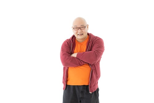 腕を組む焼き芋カラーの服を着た男性の写真