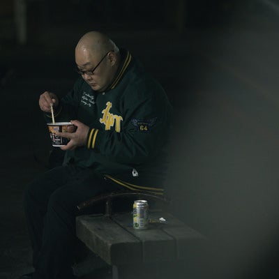 公園で寂しくストゼロとカップ麺を食べるデブの写真
