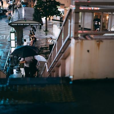 雨上がりの歩道橋と傘を差して帰路につく歩行者の写真