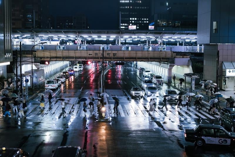 雨上がりの筑波町駅前横断歩道を歩く人々の写真